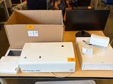 a table with a laptop, a monitor, and a printer on it