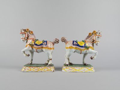 pair of porcelain figurines of a horse and rider on a green base