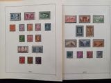 deux pages d'un livre, sur lesquelles figurent des timbres, posées sur une table