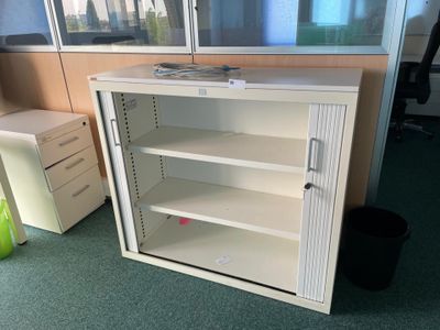 a white cabinet with shelves in an office cubicle