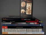 many books stacked on top of each other on a table