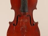 an old violin sitting on top of a white surface