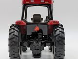 a red toy tractor that is sitting on a white surface
