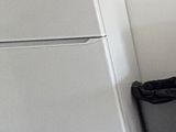 un réfrigérateur blanc posé dans le coin d'une pièce