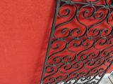 an image of a red wall with a decorative iron screen