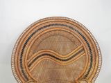 a wicker chair that has a black and white stripe on it