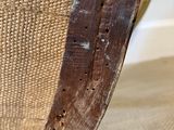 the back of a wooden chair with holes in the seat