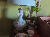une table sur laquelle se trouvent une lampe, une théière, une tasse à thé et une boîte