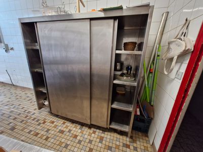 un meuble en acier inoxydable dans une cuisine, avec une porte rouge