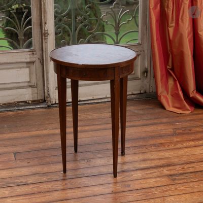une petite table posée sur un parquet, devant une fenêtre