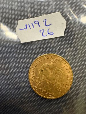 a close up of a gold coin with a note attached to it