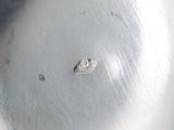 an antique silver plate with a small diamond on it
