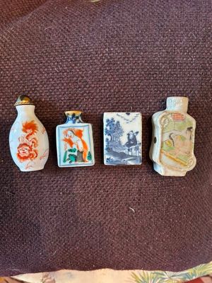 cinq petites bouteilles posées sur un coussin marron