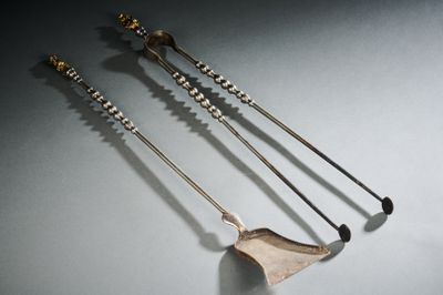 trois cuillères en argent et un repose-cuillère posés sur une table