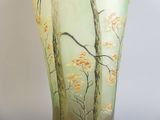a glass vase with a painting of trees on it