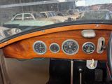 dashboard of a car with gauges and a steering wheel in a parking lot