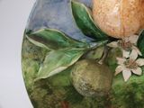 a ceramic plate with a fruit and flower decoration on it