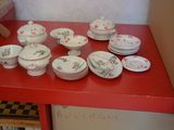 a red table with a bunch of plates and bowls on it