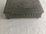 an antique brass box on a white tablecloth with a white background