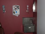une photo d'une salle de bains avec un lavabo et des murs rouges