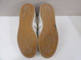 pair of white tennis shoes sitting on top of a white surface