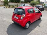 une petite voiture rouge garée sur un parking