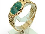 an image of a gold bracelet with a green stone on it