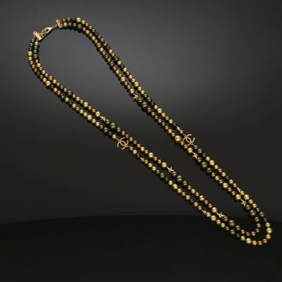 un collier de perles dorées et noires sur fond noir