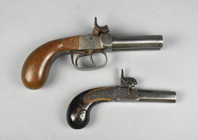 deux vieux revolvers posés côte à côte sur une surface blanche