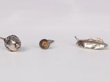 two silver spoons and a spoon rest on a white surface