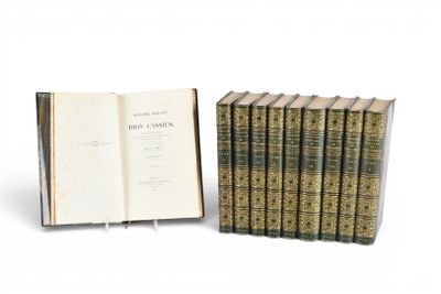 un livre ouvert posé à côté d'une pile de livres sur une surface blanche