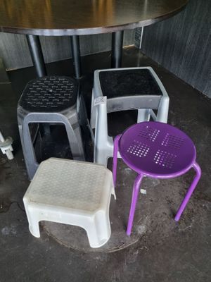 four stools and a table in the corner of a room
