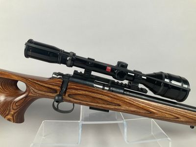a rifle with a scope and a scope scope on a stand