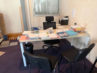 un bureau avec deux chaises et un ordinateur dessus