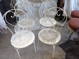 four chairs and a table in a room with a chair and a table