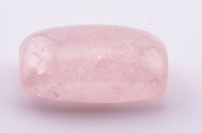 un gros plan d'un quartz rose posé sur une surface blanche