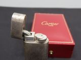 an old silver lighter sitting on top of a table next to a red box