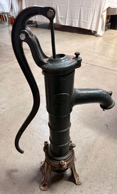 une pompe à eau à l'ancienne posée par terre dans une pièce