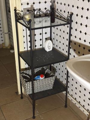 a black and white tiled bathroom with a sink and a shelf