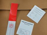 a cardboard box with a red and white sticker on it