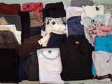une grande quantité de vêtements posés sur une étagère dans une pièce