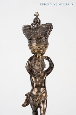 une image représentant la statue d'un garçon tenant une couronne sur la tête