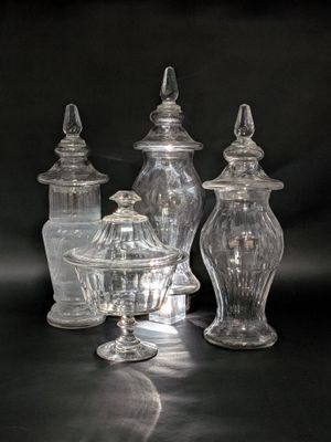 three clear glass jars with lids on a black surface