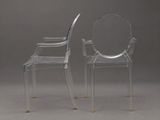 two clear chairs sitting next to each other on a gray surface