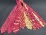 several ties of different colors are tied together on a black surface
