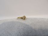 gros plan d'une bague en or sur une surface blanche