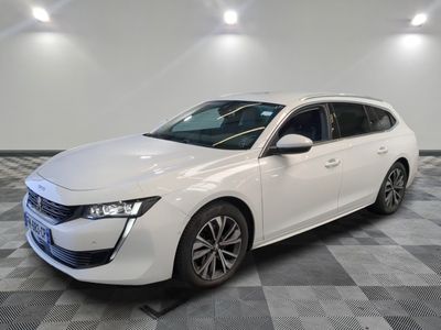 une voiture blanche garée dans une pièce au sol en damier