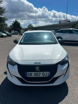 une voiture blanche garée sur un parking, avec d'autres voitures en arrière-plan