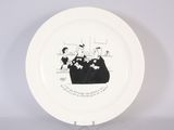 a white plate with a drawing of a man and a woman sitting on a couch