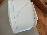 a white toilet paper dispenser hanging from a wooden beam